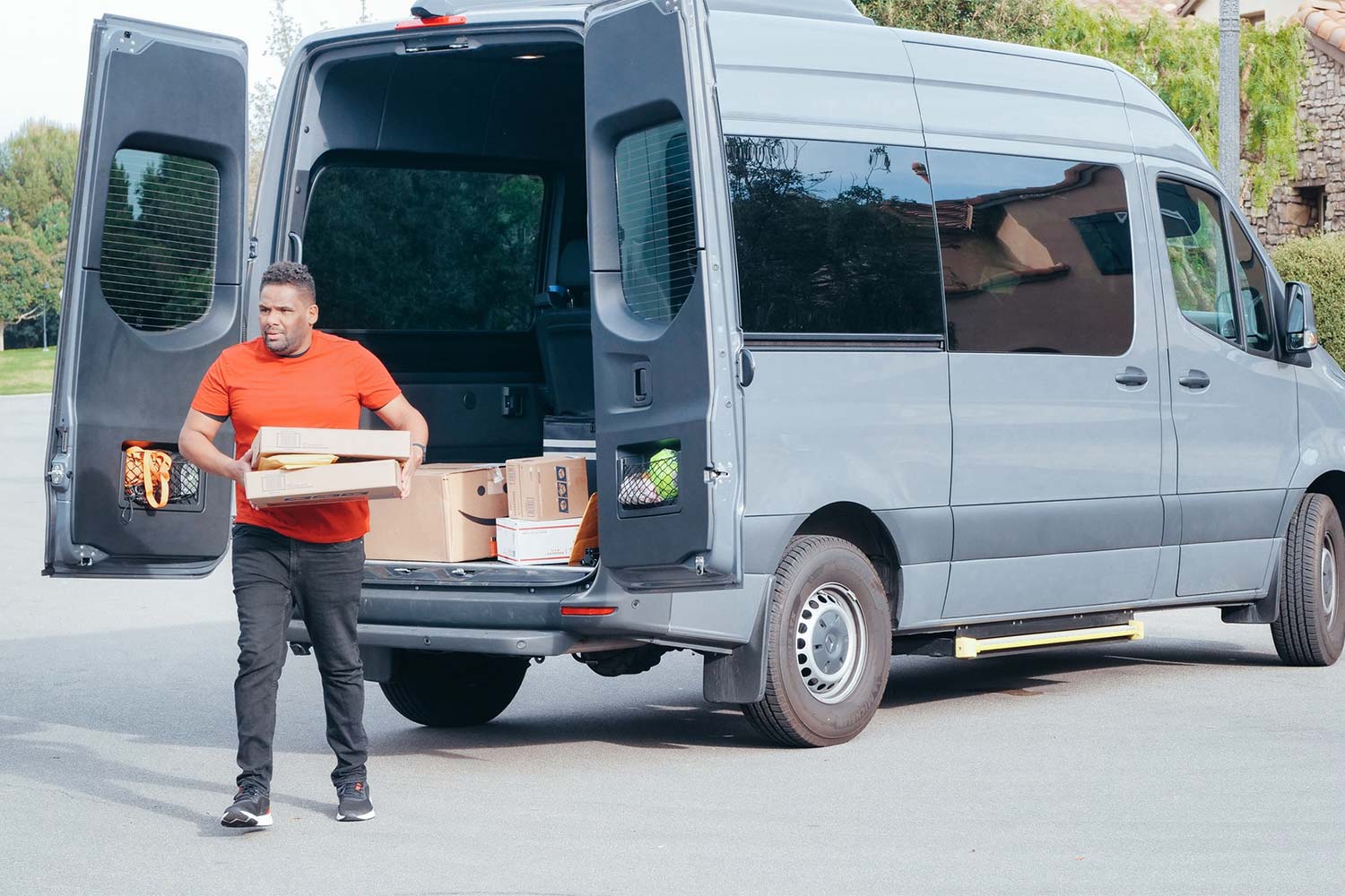 A Delivery Man Is Unloading Items From A Delivery Van