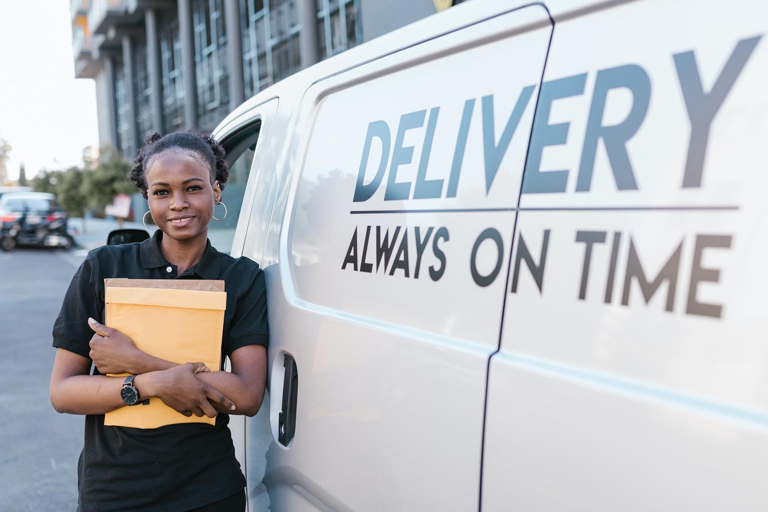 A Female Courier In Front Of The Delivery Service Van