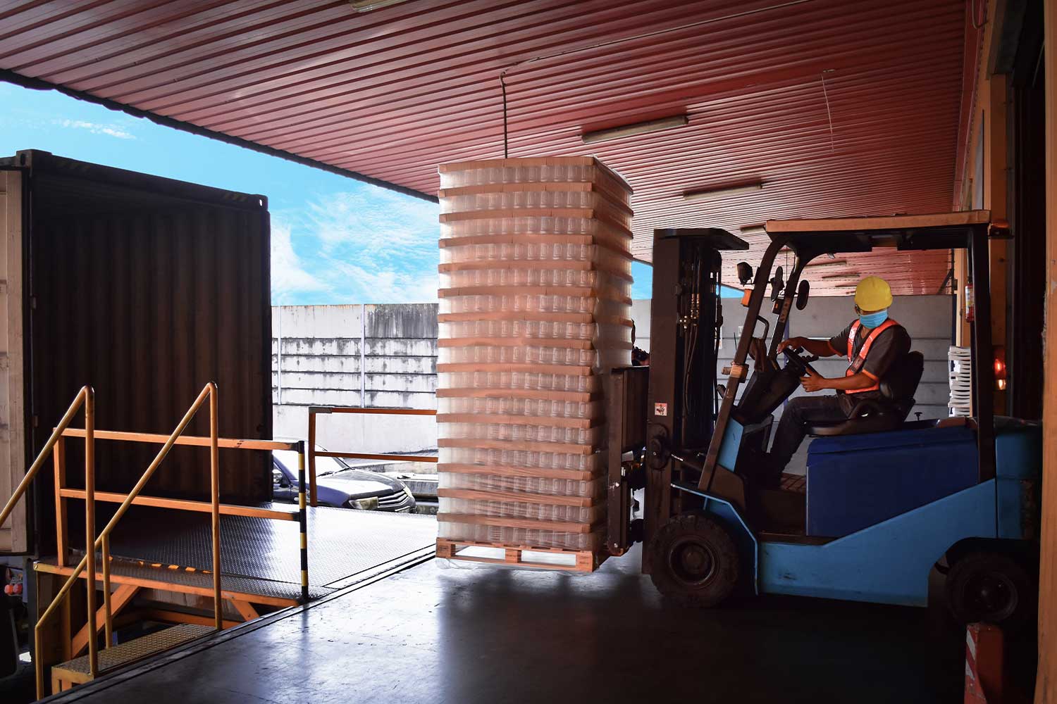 Forklift Driver On A Warehouse Platform Loads Pallets In A Delivery Truck